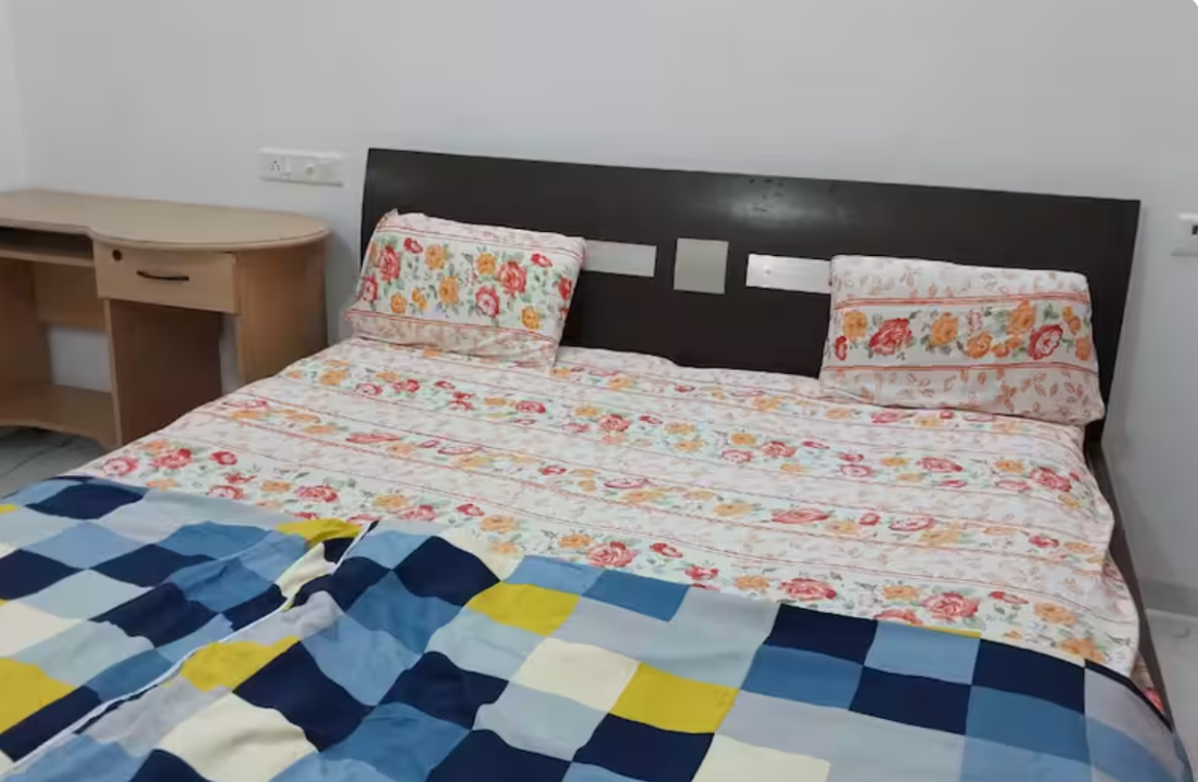Double bed with colourful bedsheet at AG House Daman